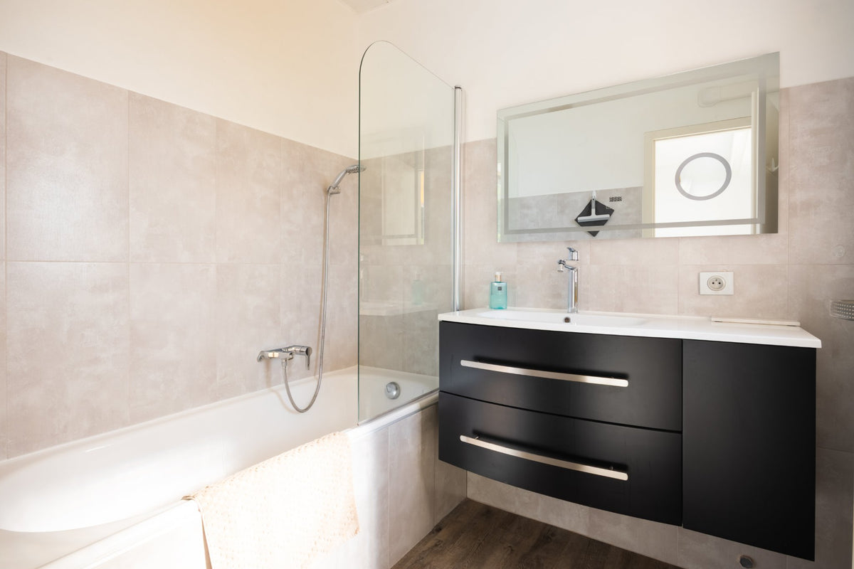 Photographie immobilière : salle de bain avec baignoire et meuble noir, Cap-d'Ail