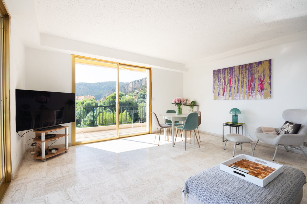 Photographe immobilier Côte d'Azur : séjour lumineux ouvert sur la terrasse, Cap-d'Ail