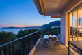 Exemple de séance crépuscule : terrasse avec vue mer à l'heure bleue, lumière intérieure chaude, appartement à Cap-d'Ail, Côte d'Azur